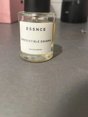 Essnce Irresistible Enigma EdP - Upptäck Essnce Irresistible Enigma Eau de Parfum  dupe på Prada paradoxe– en stilren parfym med modern känsla. Perfekt för dig som vill sticka ut och addera en mystisk touch till din look.