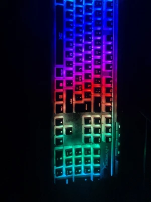 HyperX RGB Gaming Keyboard - Snygg HyperX gamingtangentbord med RGB-belysning och numerisk del. Tangenterna lyser i flera färger och ger en cool spelkänsla. Något dammigt men i gott skick, alla tangenter syns tydligt och fungerar. Perfekt för gaming och arbete.