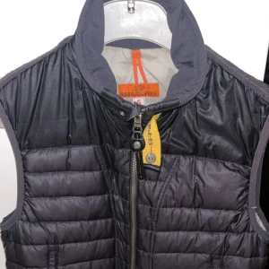 Parajumper väst  - Snygg svart väst från parajumpers perfekt för lager på lager, den har en snygg gul detalj och är perfekt för dig som vill göra din outfit komplett. OBS Hål i vänster ficka som ni ser på bilden. PRIS KAN DISKUTERAS, vid fler frågor är det bara att skriva 