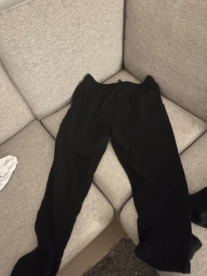 Svarta mjukisbyxor från Newbody L - Svarta mjukisbyxor från Newport i storlek L. Byxorna har en enkel design med snörning i midjan och är gjorda i mjukt material som känns skönt mot huden. Perfekta för chill dagar eller när du vill vara bekväm. Snyggt loose fit och klassisk look.