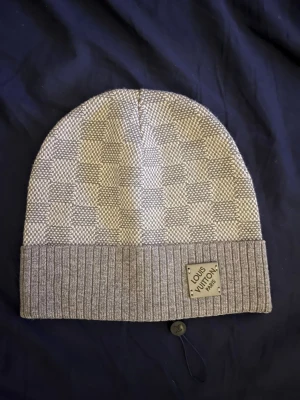 Grå mössa - Grå Louis Vuitton mössa i storlek one size, använd fåtal gånger, pris kan diskuteras