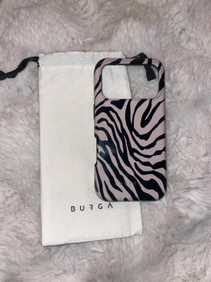 Burga iPhone 17 Pro skal Zebra - Snyggt Burga skal till iPhone 17 Pro med zebramönster. Skalet är i nyskick utan synligt slitage och levereras med original tygpåse. Ger bra skydd och har exakta utskärningar för knappar och portar. Perfekt för dig som vill kombinera stil med funktion. Om man skulle vara intresserad av fler mobilskal jag säljer hade jag kunnat sälja alla för 360kr.