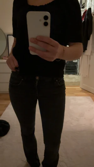 Svarta lågmidjade jeans - Säljer ett par svart/gråa jeans med lätt bootcut passform och låg midja från Zara. Klassisk femficksmodell med knapp och dragkedja framtill. Snygga att matcha med allt! Skriv till mig privat för fler bilder/frågor💕