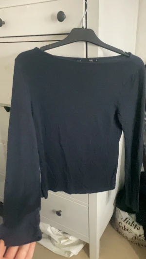 Mörkblå långärmad topp - Säljer en enkel och stilren mörkblå långärmad topp med rundad hals. Toppen har en rak passform och är tillverkad i mjukt material som känns skönt mot huden. Perfekt att matcha med jeans eller kjol för en clean look. Formar sig efter midjan man har 