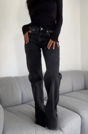 Mörkgrå raka jeans med låg midja Zara - Säljer ett par mörkgrå jeans med låg midja och raka ben. Jeansen har klassisk femficksdesign, knapp och dragkedja framtill samt en cool tvättad look. Passar dig som gillar avslappnad stil och vill ha ett par jeans som är både snygga och bekväma.