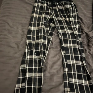 Svarta rutiga pyjamasbyxor  - Skriv om du har några frågor.