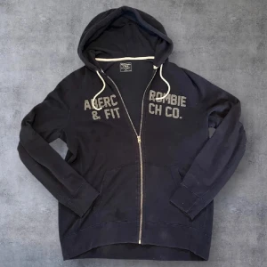 Svart ziphoodie Abercrombie & Fitch Co  - Säljer nu min feta vintage zip hoodie, den är svår att få tag på och många är intresserade av den här typen av tröjor! Storlek L/Xl passar dig som är 185-200cm Skick 7/10 Hör av dig om du har några frågor!