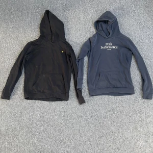 Fyra hoodies från Peak Performance, GANT, Lyle & Scott och Sail Racing - Säljer fyra hoodies: svart Lyle & Scott med gul logga, mörkblå Peak Performance med vit text, svart hoodie med dragkedja och tryck på ärmen från SAIL RACING, samt marinblå GANT med broderad logga och emblem. Alla har huva och magficka, perfekta för chill och streetwear. De är alla i storlek 170 och har tecken på användning men har mycket kvar att ge. Säljes för 150 kr styck men kan fås billigare vid snabba affär. Säljer helst allt samtidigt. Kolla min profil för mer liknande annonser. 