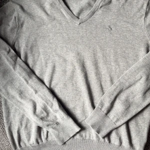 Grå v-ringad tröja från Polo Ralph Lauren - Grå v-ringad tröja från Polo Ralph Lauren i mjuk pima bomull. Storlek S men passar Xs! Skick 7,5/10 inga hål eller fläckar men är använd! 