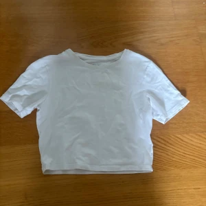 Vit basic t-shirt från 157, XS - Enkel och stilren vit t-shirt från lager 157 i storlek XS. T-shirten har rund halsringning och korta ärmar. Tillverkad i mjuk bomull med lite elastan för extra stretch. Perfekt till jeans eller shorts för en clean look.