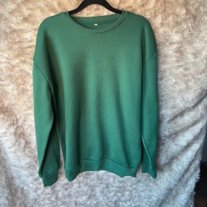 Grön sweatshirt i polyester, stl L - Grön sweatshirt i storlek L, tillverkad i 100% polyester. 