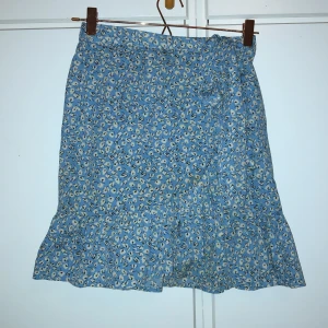 Blå blommig omlottkjol - Väldigt bra skick!!! Använt ca 2 gånger. Strl S. Från Vero Moda.
