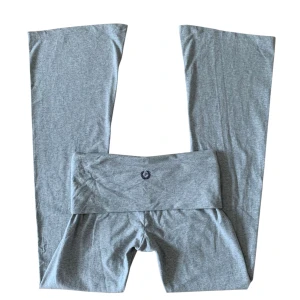 Grå low waisted bootcut leggings från PINK - Grå leggings från PINK by Victoria's Secret med bootcut-ben och bred, hög midja. Mjukt bomullsmaterial och liten broderad logga framtill. Perfekta för en chill och sportig look.