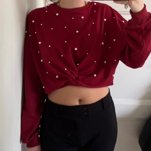 Vinröd croppad tröja med pärlor - Snygg vinröd croppad tröja med twistad front och pärldetaljer över hela. 