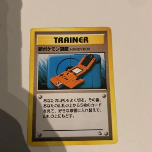 新ポケモン図鑑 HANDY808 (Trainer Card) - Klassisk japansk Pokémon Trainer-kort från 1996! Perfekt för samlare och fans av Pokémon TCG. Kortet har cool retrodesign och är en ikonisk del av Pokémon-historien. Ett måste för dig som älskar Pokémon och vill ha något unikt i din samling.