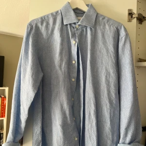 Ljusblå John Henric skjorta med mönster - Snygg ljusblå skjorta från John Henric. Tillverkad i mjuk bomull med italienskt tyg för en skön känsla och stilren look.