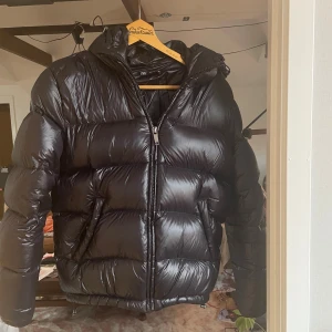 Svart pufferjacka från Zara - Säljer en svart pufferjacka/ vinterjacka från Zara i storlek S. Jackan har glansig finish, huva och dragkedja framtill. Den håller dig varm under kalla dagar. Pris kan diskuteras, hör av er vid frågor!✌️