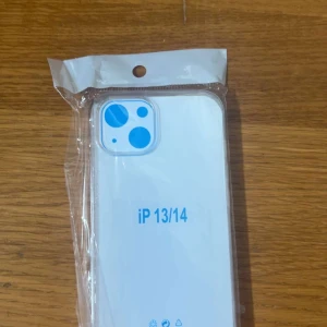 iPhone 13/14 Transparent Skal fri frakt - Helt nytt, transparent skal för iPhone 13 och iPhone 14. Tillverkat i mjuk och tålig plast som skyddar din mobil mot repor och stötar. Skalet är oanvänt och levereras i originalförpackning. Perfekt passform med utskärning för kamera och knappar. Pris kan diskuteras.