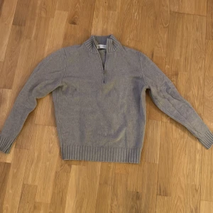 Grå halvzip-tröja Filippo De Laurentiis S - Snygg grå stickad tröja från Filippo De Laurentiis i ull och kashmir. Tröjan har ribbad krage, muddar och nederkant samt en praktisk half zip-dragkedja framtill. Perfekt för lager-på-lager och chillare dagar. Säljer nu denna eftertraktade Zip hoodie som är Cashmere. Storlek S. Säljer då den inte passar mig längre. Ny pris 3500kr
