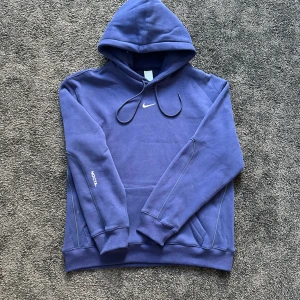 Blå Nocta X Nike hoodie : M  - En nocta hoodie med en sinnesjuk design Storlek M Skick : otroligt bra så nära ny som möjligt. Andvänd 1/2 gånger. Hör av er vid funderingar ☺️💬 