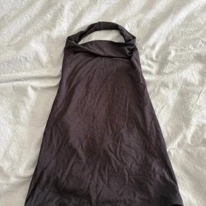 Svart halterneck topp Gina Tricot - Säljer en svart halterneck topp från Gina Tricot i mjuk bomull. Toppen är ärmlös med knytband i nacken och har en clean, minimalistisk look. Perfekt att styla med jeans eller kjol för en trendig vibe. Storlek M