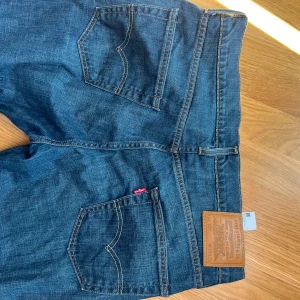Levi's 527 blå bootcut jeans - Klassiska Levi's 527 jeans i mörkblå färg med bootcut passform. Perfekta för dig som gillar en tidlös look med lite utsvängda ben. Nyskick 10/10!