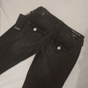 Nya Bootcut jeans från True Religion - Helt nya oanvända med prislappen av därav jag trodde jag skulle använda dom men aldrig gjort. Modellen är Joey Low Rise Flare och storlek 25. Färg Charcole. Midjemått 36cm innerbenslängd 80cm!