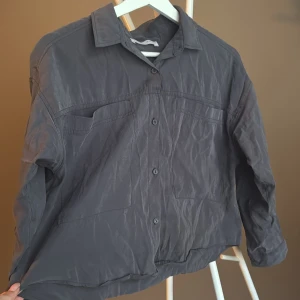 Grå skjorta från Zara med knappar - Säljer en stilren grå skjorta från Zara i storlek 164. Skjortan har klassisk krage, knäppning framtill och en bröstficka. Långärmad modell i ett lätt material som passar perfekt till olika outfits. Men passar en vuxen storlek S och liten M.🌸