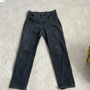 Svarta Flash jeans straight fit - Svarta jeans från Flash Jeans i modellen Sanna, med klassisk femficksdesign och kontrastsömmar. Raka ben och normal passform. Materialet är 98% bomull och 2% elastan för lite stretch. Snygga bakfickor med dekorativ söm.