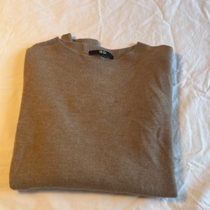 Beige kashmirtröja från Uniqlo XS - Mjuk och stilren beige tröja från Uniqlo i kashmir. Klassisk rund halsringning, ribbade muddar och lång ärm. Perfekt för lager-på-lager och enkel att matcha med allt. Snygg basic som funkar året runt.
