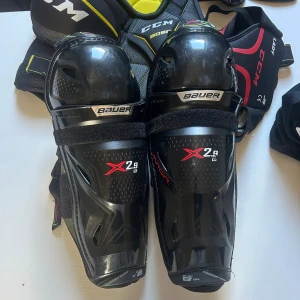 Hockeyskydd - Benskydd/knäskydd. Bauer JR 13” /33cm. Nypris 999kr. Använda i knappt 1 säsong. Så väldigt bra skick. Finns enstaka märken, som syns på bilderna.