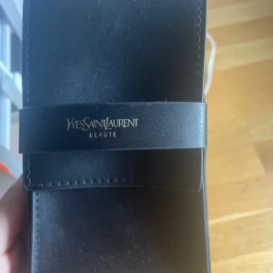 Yves Saint Laurent parfymfodral - Säljer denhär fodral från Yves saint laurent helt äkta som är perfekt att lägga sminkborstar i eller egentligen vad som helst i.
