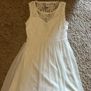 Vit spetsklänning - Superfin vit klänning från Vero Moda med spets. Perfekt för student! Klänningen är i storlek S🤍