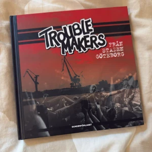 Troublemakers från staden Göteborg - En bok om punkbandet Troublemakers från Göteborg, fylld med bilder, berättelser och minnen från bandets historia. Perfekt för dig som älskar musik, punk och Göteborgs kulturliv. Upptäck bandets resa och energi genom unika foton och personliga texter.