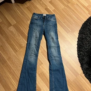 Blå bootcut jeans från ONLY S/32 - Snygga blå jeans från ONLY i bootcut-modell. Jeansen har fem fickor, normal passform och är tillverkade i jeansmaterial. Längst ner på högerbenet är det en liten slitning (se bild)💗