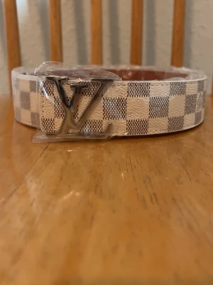 L-v Bälte vit rutig - Säljer ett helt nytt riktigt snyggt vit,beige L-v bälte