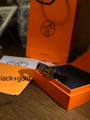 H Armband - H armband i svart och guld mycket fint och elegant