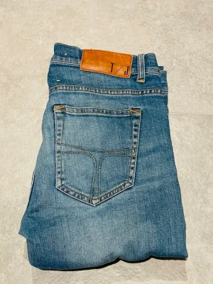 Tiger of Sweden jeans - Snygga blå jeans från Tiger of Sweden med klassisk femficksdesign och ljus tvätt. Jeansen har en rak passform och är tillverkade i 98% bomull och 2% elastan för extra komfort. Perfekta för dig som gillar stilrena och tidlösa jeans.