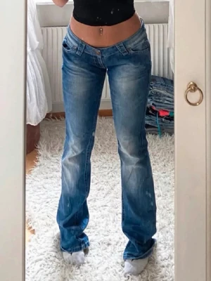 Blå bootcut jeans Lost in Paradise - Säljer ett par blå bootcut jeans från Lost in Paradise i storlek 31/34. Jeansen har låg midja. Snygga slitningar framtill och bak ger en cool vibe. 