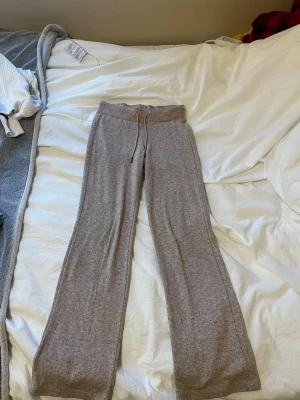 Beige mjukisbyxor med snörning - Mysiga beige mjukisbyxor med bred resår i midjan och snörning framtill. Byxorna har raka ben och är gjorda i ett mjukt material, säljs då de är för korta 