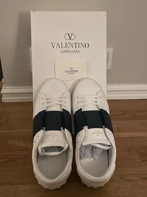 Valentino Garavani Open - Säljer ett par vit/blå Valentino Garavani Opens. Köpta ett tag sen men knappast tecken på användning då de användes försiktigt och noggrant tvättade. Är själv den andra ägaren, köpta för ett högt pris. Hör av dig vid frågor och funderingar! Pris kan alltid diskuteras vid smidig och snabb affär!! 🙌