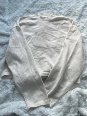 Ljusbeige stickad tröja - En enkel och stilren ljusbeige stickad tröja med rund hals och långa ärmar. Perfekt för lager på lager och passar till allt. Mjuk och skön känsla, lätt att matcha med jeans eller kjol.
