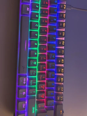 Xtrfy RX5 Mechanical Mini Keyboard - Xtrfy RX5 mekaniskt mini-tangentbord med RGB-belysning. Kompakt design, nordisk layout och USB-anslutning. Tangenterna lyser i flera färger och tangentbordet är i fint skick utan synliga defekter. Perfekt för gaming eller arbete där platsbesparing är viktigt.