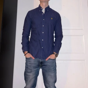 Mörkblå skjorta från Ralph Lauren - Mörkblå skjorta från Ralph Lauren i storlek M.  Fint skick till ett bra pris. Nypris: 1995kr. Mitt pris: 349kr. Vid frågor eller funderingar, tveka inte att höra av dig.