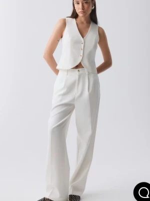 Vita kostymbyxor med wide fit - Snygga vita kostymbyxor från ginatricot med hög midja och raka ben. Byxorna har pressveck, hällor för bälte och stängs med knapp och dragkedja. Perfekta för en clean och stilren look, tillverkade i ett mjukt material som ger en dressad känsla. Använt en gång. 