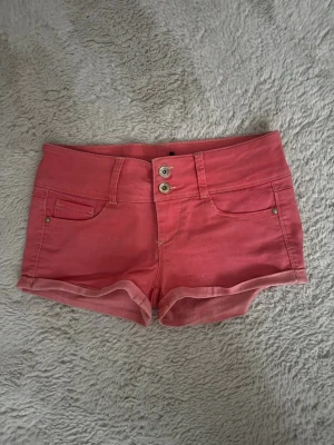 Lågmidjade jeansshorts  - Korallfärgade lågmidjade jeansshorts i storlek M ifrån Tally weijl, midjemåttet är 37cm! 