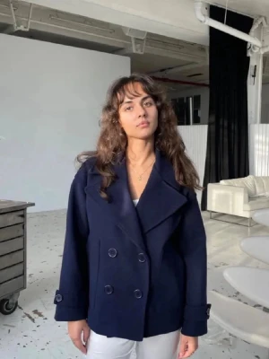 Mörkblå skepparkavaj från design by si - Säljer en stilren mörkblå skepparkavaj med dubbelknäppning och stora slag. Jackan har klassisk marin känsla, knappar framtill och vid ärmslut samt är helfodrad. Perfekt för dig som vill ha en tidlös och snygg look.