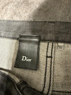 Grå raka jeans , storlek 30 - Säljer ett par grå jeans från i rak modell. Jeansen har klassisk femficksdesign, knappgylf och är tillverkade i ett slitstarkt jeanstyg. Snygg diskret tvätt och stilren look som passar till det mesta. Märkespatch i svart läder på insidan av linningen. Kan inte skriva riktiga märket för annonsen listas ej då.