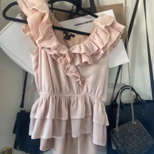 Ljusrosa volangblus från H&M - Populär supersöt ljusrosa blus med volanger från H&M. Sitter som en S men stretchig. Fint skick! 