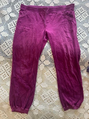 Lilarosa mjukisbyxor med resår och snörning - Mysiga lila mjukisbyxor med resår i midjan och benslut samt snörning framtill. Byxorna har två fickor fram och är tillverkade i mjuk sammet. Finns ingen prislapp men skulle säga 2XL.